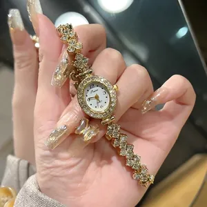 Details der luxuriösen Gold-Damenuhr mit Kristall-Lünette und Gliederarmband am Handgelenk