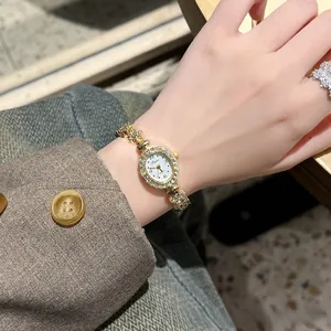 Makro-Detail einer Luxus-Quarzuhr mit Strass am Handgelenk einer Frau