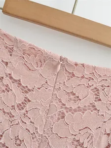 Detailed close-up of light pink lace fabric with high-quality invisible zipper on the waist