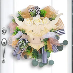Highland cow floral wreath with eucalyptus leaves and multi-colored ribbons on white door