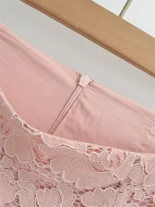 Close-up of invisible back zipper and intricate floral lace on a pink high-waist skirt