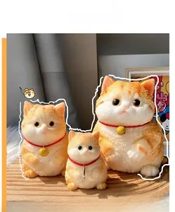 Three orange tabby cat squishy stress relief toys with bells on a wooden base