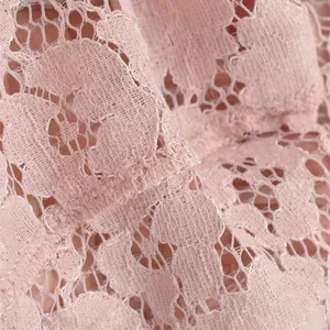 Close-up of pink lace fabric detail with floral embroidery for elegant high waist skirt