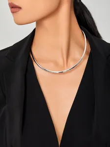 Gros plan d'un choker argenté minimaliste sur un mannequin portant un blazer noir