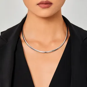 Collier minimaliste en acier titane argenté porté avec un blazer noir élégant