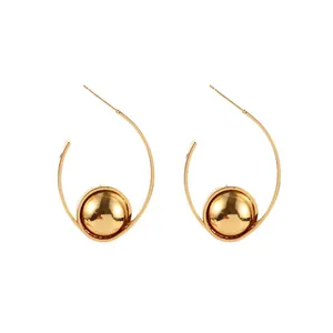 Minimalist gold C-shaped geometric hoop earrings with a polished metal ball charm