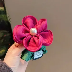 Handmade rose red floral hair scrunchie with white pearl center and green leaf detail