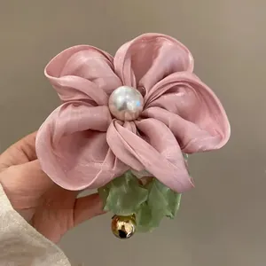 Pink silk floral scrunchie with large center pearl and green leaf detail for women