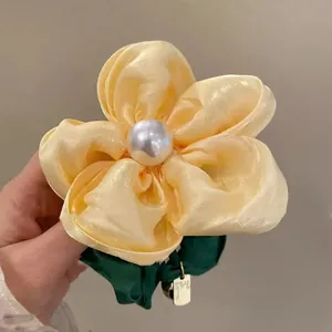 Elegant pale yellow flower scrunchie with white pearl center and green elastic band