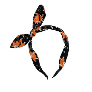 Halloween bunny ear headband featuring spooky skull and spider web prints in orange and black