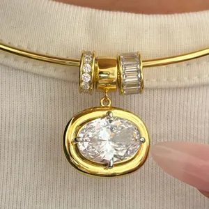 Macro detail of gold torque necklace with oval cut zircon pendant and decorative sliders