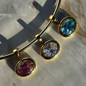 Luxury gold choker necklace with three oval gemstones in pink, white, and sky blue