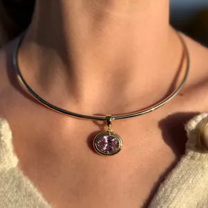Gold neck ring with large oval pink gemstone pendant worn by a model in luxury style