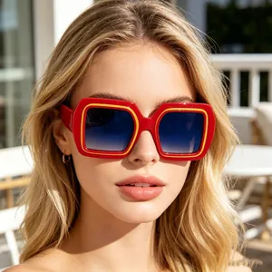 Détail de lunettes de soleil carrées rouges avec bord jaune et verres dégradés bleus