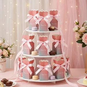 Close-up of thank you gift boxes with pink ribbon on a display stand for wedding favors