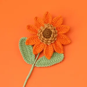 Handgefertigte Häkel-Sonnenblume mit orangefarbenen Blütenblättern auf orangefarbenem Grund