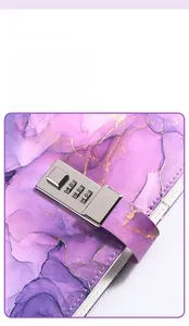 Close-up of a silver 3-digit metal combination lock on a purple marble A5 diary
