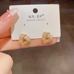 Golden triangle knot stud earrings with pave crystals on display card for women