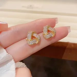 Close-up of elegant gold triangle knot earrings with pavé set sparkling crystals