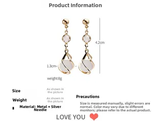 Detailed view of long gold tassel earrings with pearls and size measurements 4.2cm