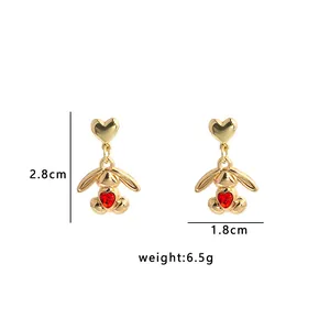 Detailed size view of gold heart and rabbit earrings with red gems, 2.8cm height