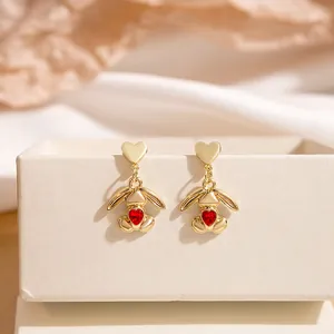 Detail of bunny drop earrings with red heart crystals on premium champagne satin background
