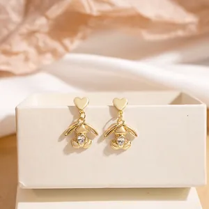 Close-up of gold bunny earrings with crystal heart inlay on a premium gift box