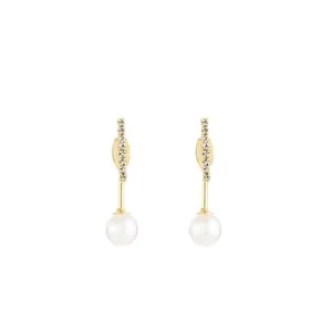 Macro shot of long gold earrings featuring sparkling crystals and smooth pearl pendants
