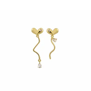 Detail of asymmetric gold heart earrings with wavy drops and sparkling zircon stones