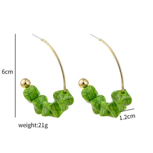 Detailed view of green marble pattern beads on golden hoop earrings with 6cm length dimensions