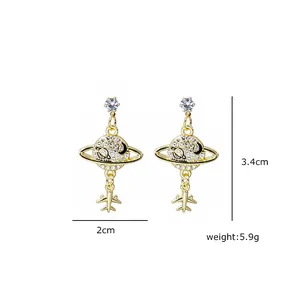 Detail of gold tassel earrings with rhinestone planet and airplane pendants, 3.4cm length