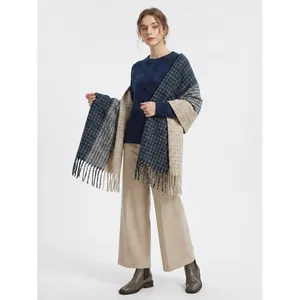 Close-up of thick winter scarf with navy blue plaid patterns and long tassel details