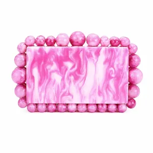 Detail view of pink marble acrylic evening bag with decorative round bead frame