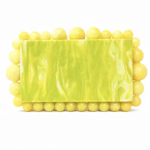 Detail of yellow and green marble acrylic evening bag with beaded decorative border