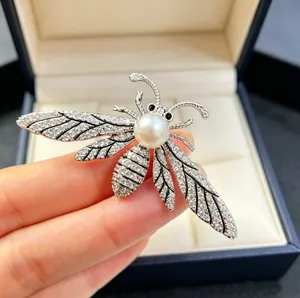 Exquisite bee brooch with sparkling crystals and a large white pearl in a silver finish