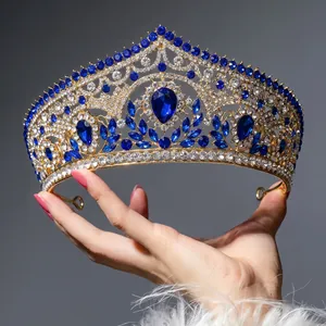 Luxury gold tiara for brides with central blue teardrop gemstone and sparkling rhinestones