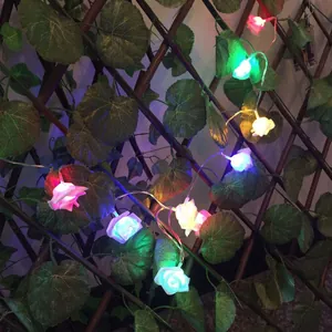 Solar powered multi-colored LED rose flower string lights on a wooden fence for garden decor