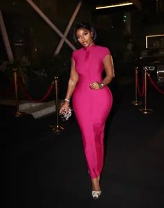 Hot pink bodycon bandage maxi dress with high collar worn on red carpet at night
