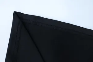 Macro shot of precise hem stitching and smooth black fabric texture on the dress