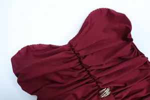 Detail of wine red ruched dress fabric with silver wavy metal ring and pleat texture