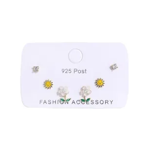 6-piece gold stud earring set featuring stars, moons, smiling suns and white floral designs
