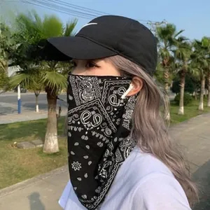 Close-up of black bandana with white paisley pattern worn as a protective face mask
