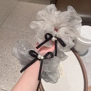 Detail of Korean style mesh bow scrunchies with pearls and black ribbons in grey and beige