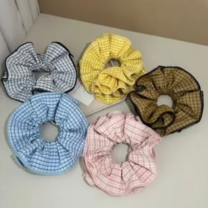 Detailed view of checkered fabric hair scrunchies set in various colors and patterns
