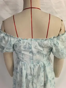 Detail van de onzichtbare rits en bloemenprint op de lichtblauwe zomerjurk