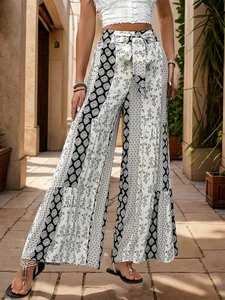 Detail of high-waist boho wide-leg pants with tiered print and matching tie belt