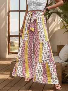 Close-up of high-waisted tiered wide leg pants with floral print and waist tie detail