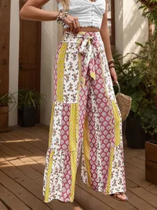 Detail of high waisted wide leg pants with ethnic floral patchwork and bow tie waist belt
