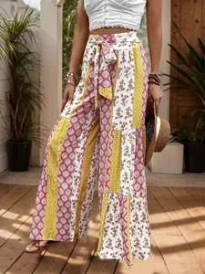 Detail of high-waisted wide-leg pants with bohemian patchwork patterns and tie-waist design
