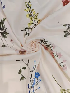 Gros plan sur un tissu fleuri crème avec d'élégants imprimés jaunes et roses